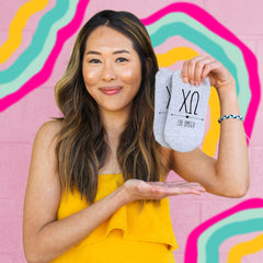 This is an image of a girl holding Chi Omega Boho Greek Letter Printed No-Show Socks.