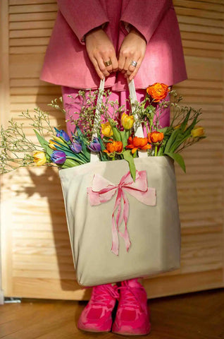 pink coquette bow on a canvas tote filled with flowers