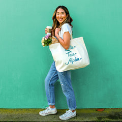 This is an image of a girl holding the Sorority Name in Watercolor Stylized Script Tote Bag.