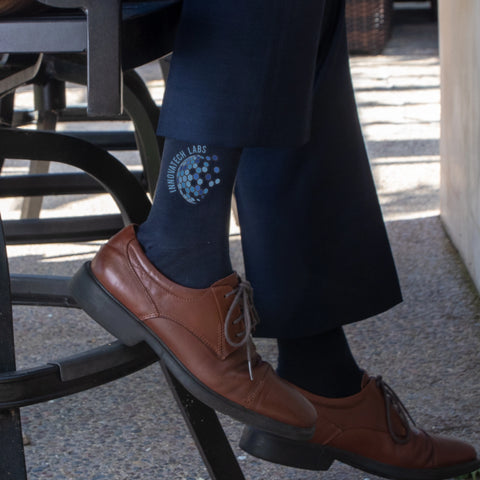 tech company logo on navy dress socks worn by a man