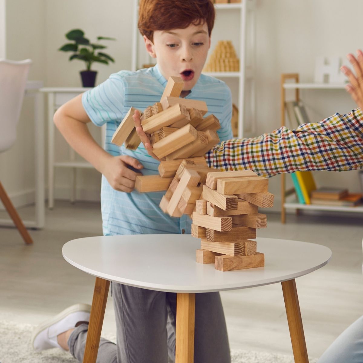 Young boy playing game of Jenga on a staycation