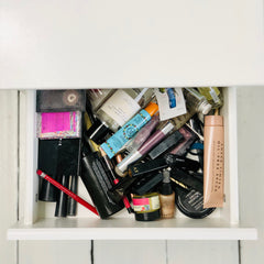 messy makeup and cosmetics in a dressing table drawer