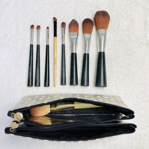 Makeup brushes in folding makeup bag with compartments