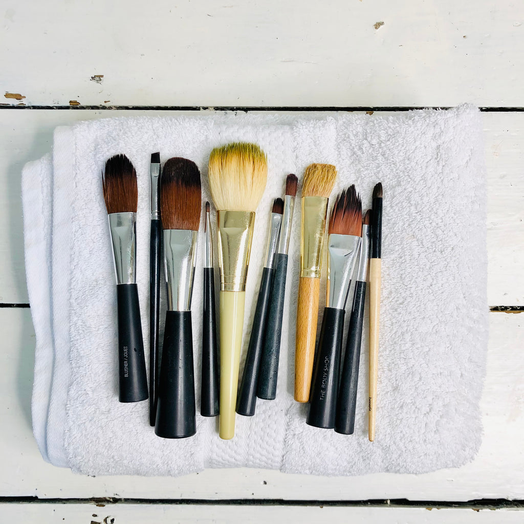 Selection of makeup brushes lined up on a white towel