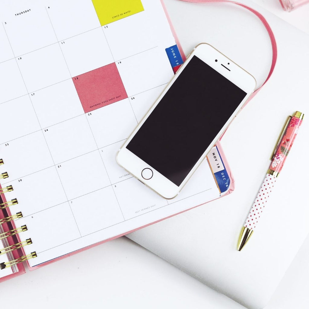 Calendar notebook and mobile phone for how to get organised this month may