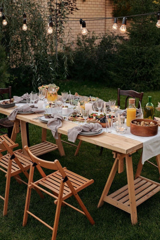 Outdoor dining setting of a decorated table with chairs and lights