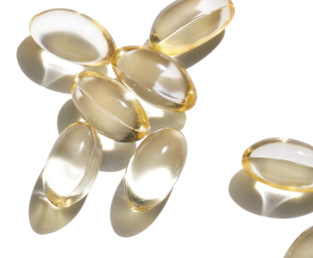 seven transparent vitamin capsules on a white background. 