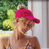 woman in pink messy bun lycra baseball cap