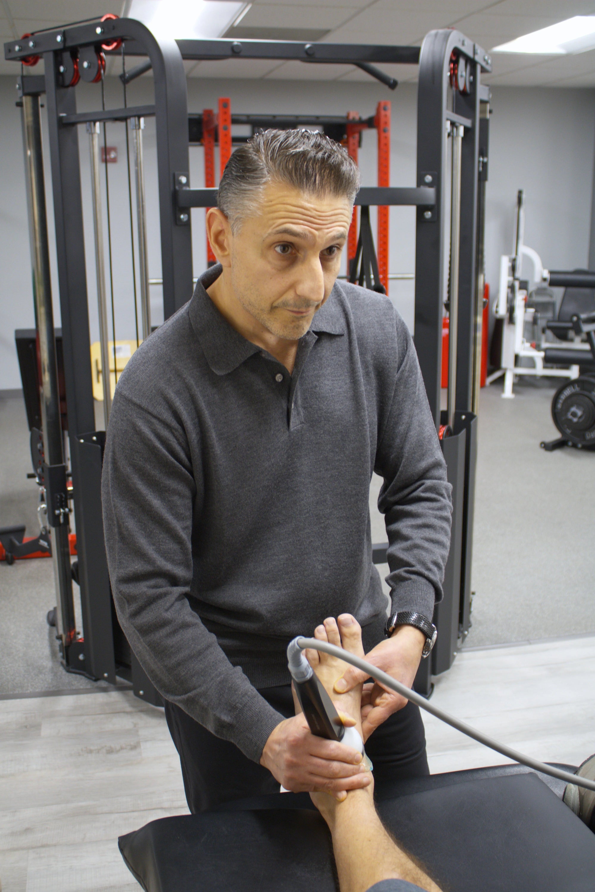 Dr Rob Letizia DPT performing FDA-cleared shockwave therapy treatment on patient foot for plantar fasciitis at Spectrum Therapeutics Wayne NJ clinic