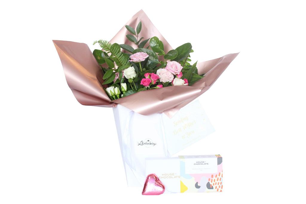 Pink and white roses packed in a white deluxe white gift bag with House of Chocolate bonbons six pack and a chocolate heart