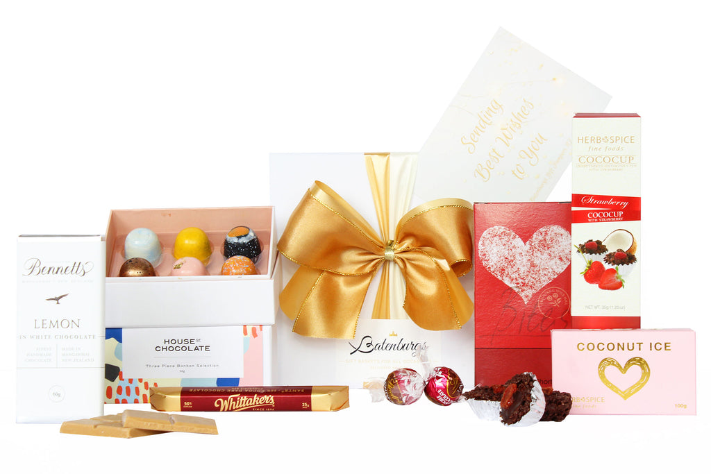 White gift box with House of Chocolates bonbon three packs, Bennett's of Mangawhai chocolate bar, Whittaker's chocolate bar 25g, two individual Lindt Lindor chocolate bites, shortbread, cococup with strawberry and coconut ice 