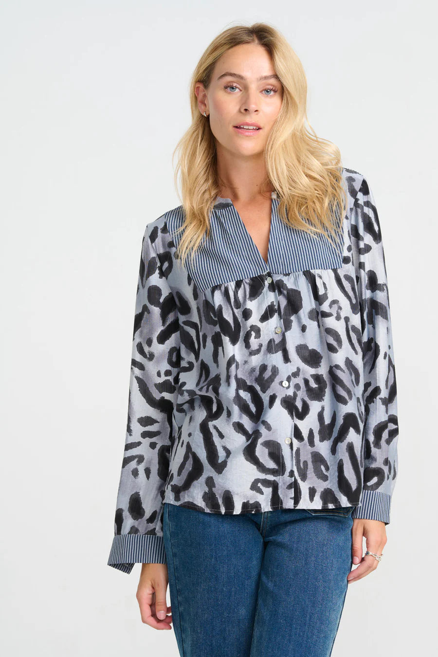 Woman wearing a patterned blouse with a plain background