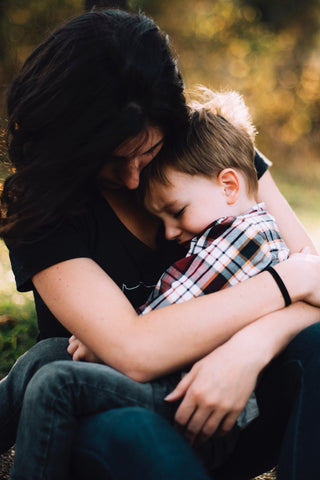 young boy being held by a woman