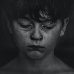 close up of boys face with tears down his cheeks