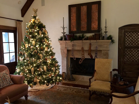 A classic Christmas mantelpiece style, with a cosy fire place and beautifully lit Christmas tree