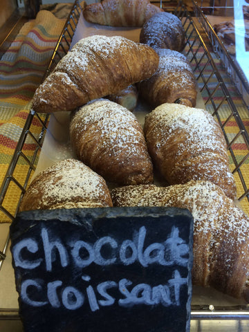 Display basket with fresh chocolate croissants dusted with powdered sugar