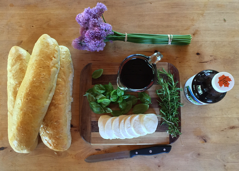 Ingredients for crostini topped with mozzarella, tomato, basil, and maple balsamic reduction.