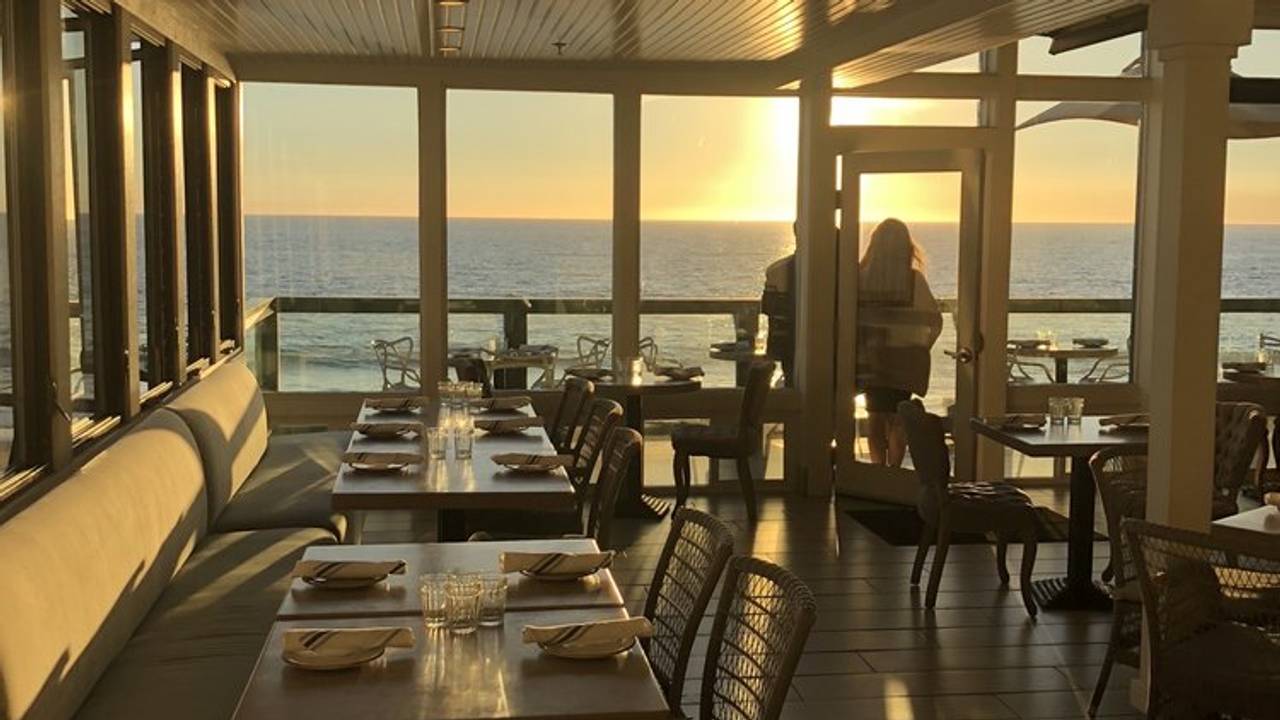 A photo of the interior of a restaurant over looking the ocean.