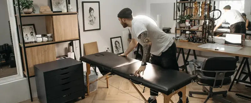 Tattoo artist fixing a bed inside a tattoo studio