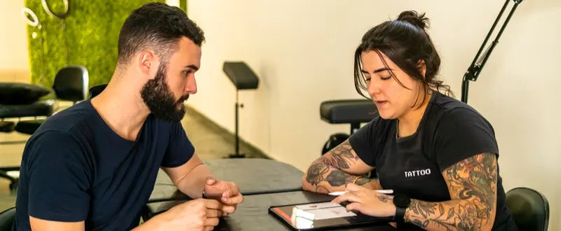 Tattoo artist talking with a client