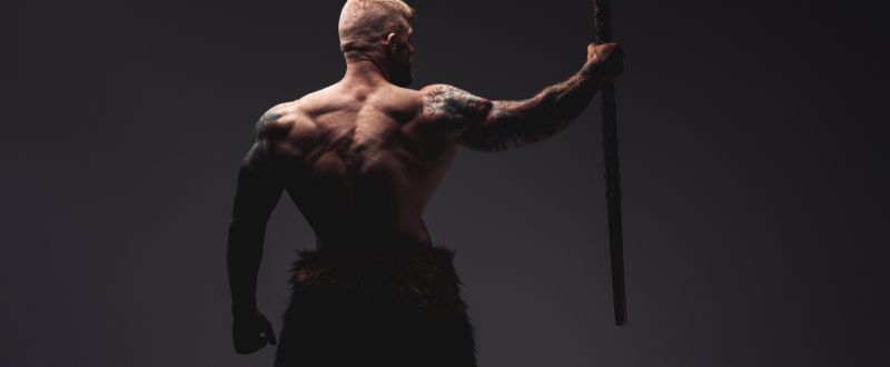 Tattooed Viking with Steel Axe His Back Facing to Camera