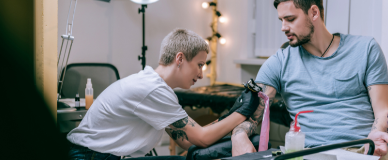 a female tattoo artist tattooing her client