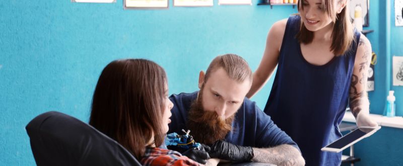 a tattoo apprentice watching during tattooing session