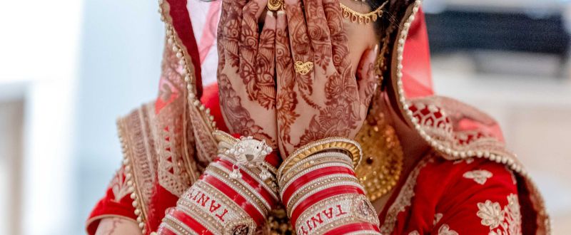 a woman covering her face using her hands with red tattoos