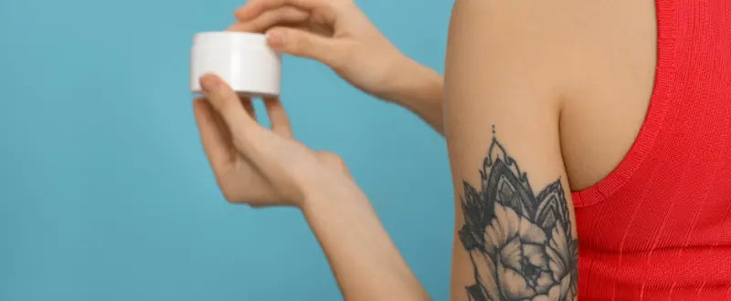 a woman holding a tattoo aftercare cream