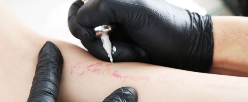 an artist doing arm tattoo