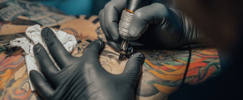an artist doing colour realism tattoo at the back
