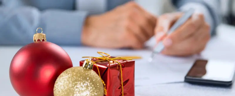 man writing with gifts on the table