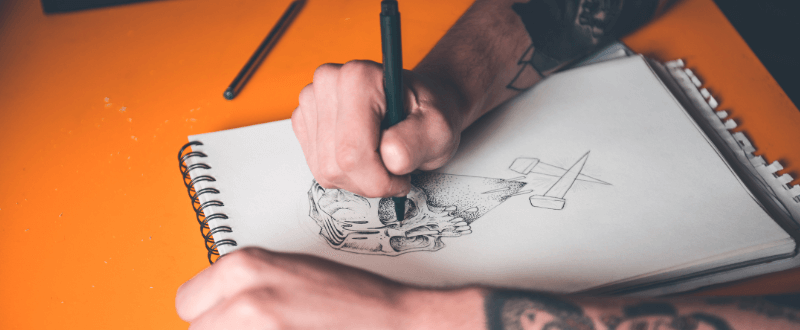 Tattoo artist drawing a new tattoo design