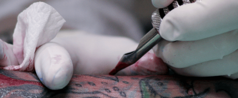 Tattoo needles depositing ink in skin