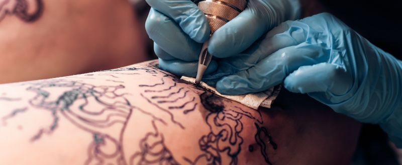 tattoo artist doing a line work tattoo