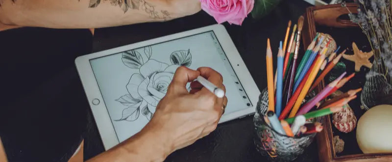 tattoo artist drawing on a tablet