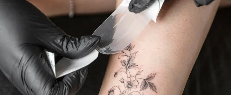 tattoo artist making leg tattoo