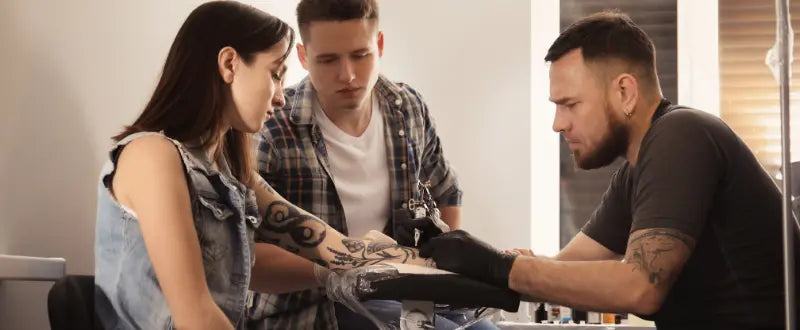 tattoo artist with his two clients