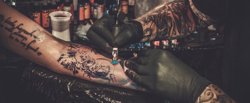 tattoo client having arm tattoo