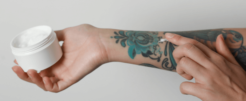 Woman applying tattoo aftercare