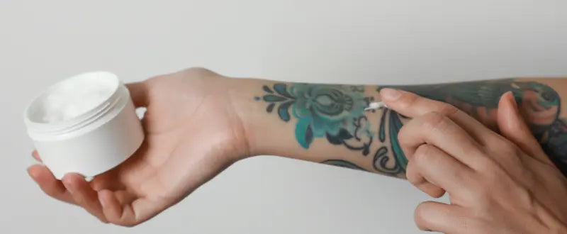 woman applying cream to her tattoo