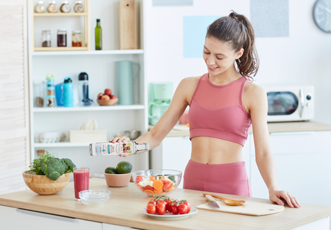 Woman preparing food with CocoTherapy MCT oil