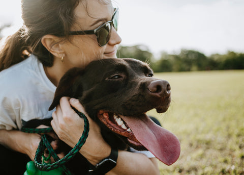 Dog owner hugging a happy dog