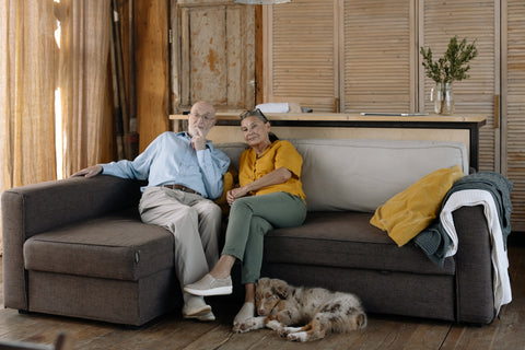 Older couple on couch thinking about the future of their dog