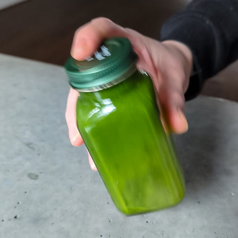 Matcha shaken in small glass container
