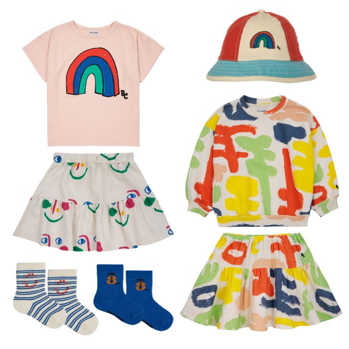 Bobo Choses SS24 Collection Rainbow Tee, Rainbow Bucket Hat, Carnival All Over Sweatshirt, Carnival All Over Woven Skirt, Smiling Mask All Over Skirt, and Baby Acoustic Guitar Sock Set at Design Life Kids