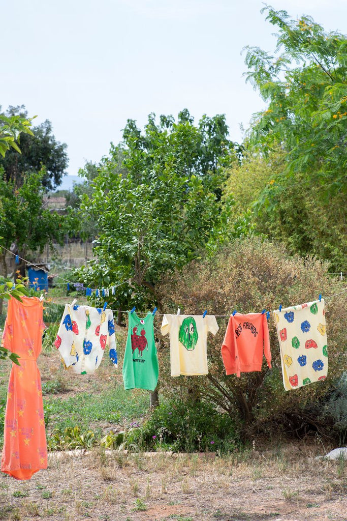Fresh Dinosaurs SS24 Collection hanging on a clothesline outside at Design Life Kids