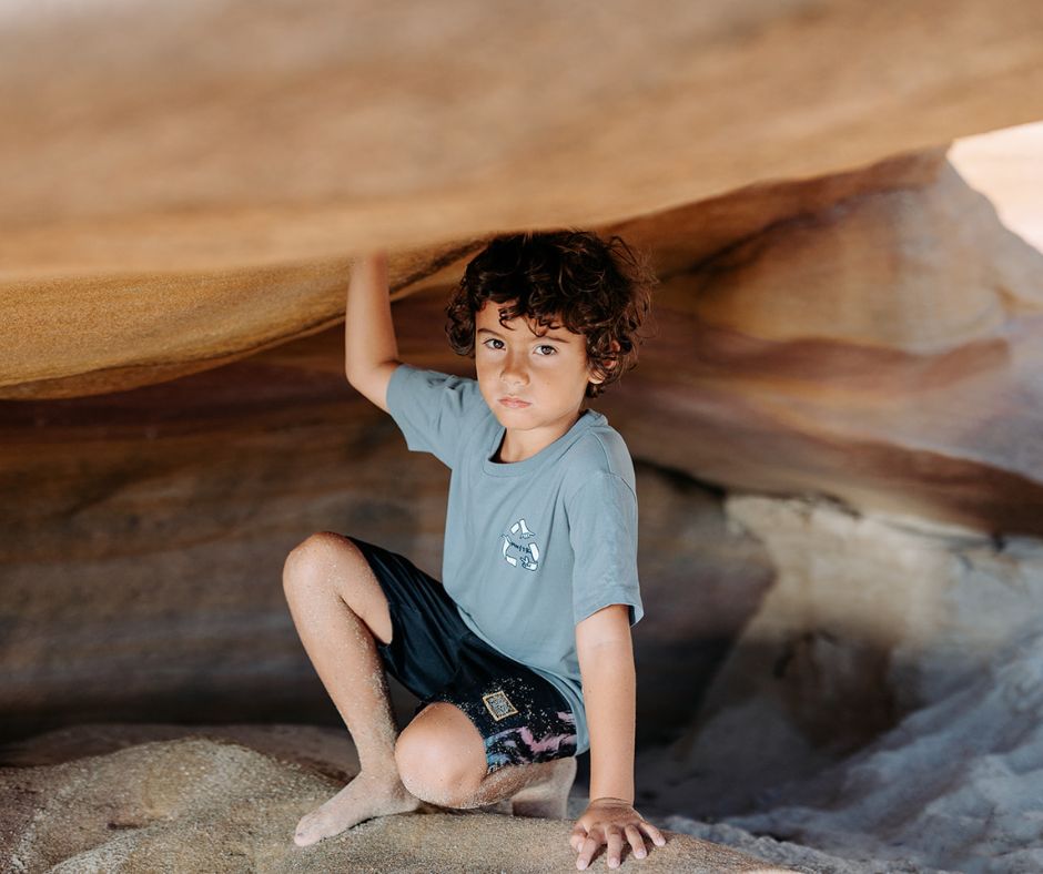 Young boy sitting on rocks in Munsterkids Royal Tee at Design Life Kids