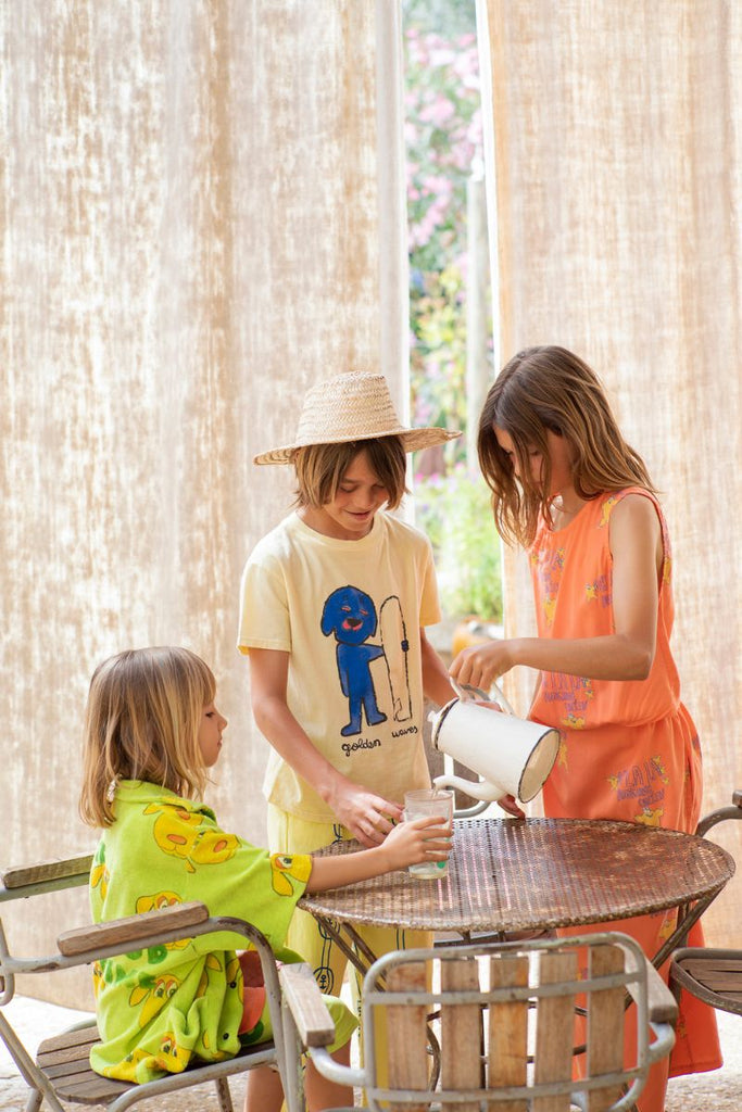 Young children pouring glasses of water in their new Fresh Dinosaurs SS24 collection at Design Life Kids