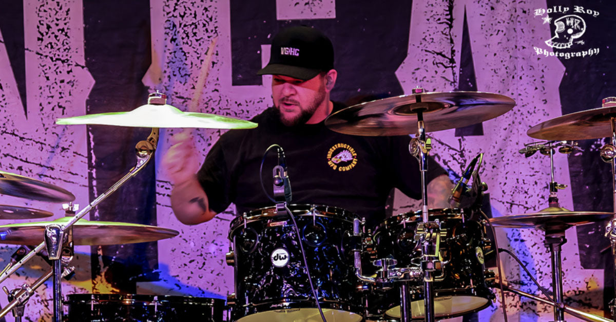 Drummer Sam Gaulin poses with Scorpion Percussion drumsticks behind his drumkit